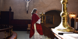 Pastor Maria Fihl stands in front of the altar in her special pentecostal pastoral gown