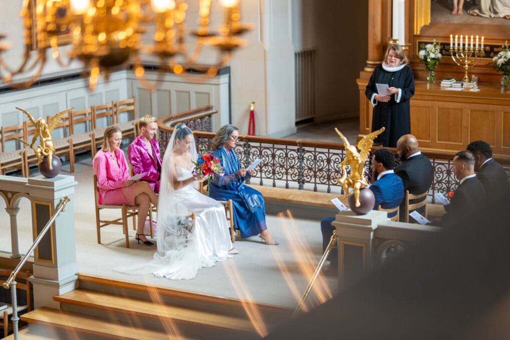 Marriage 2 in front of the altar in a church, a wedding party is singing from the hymn book