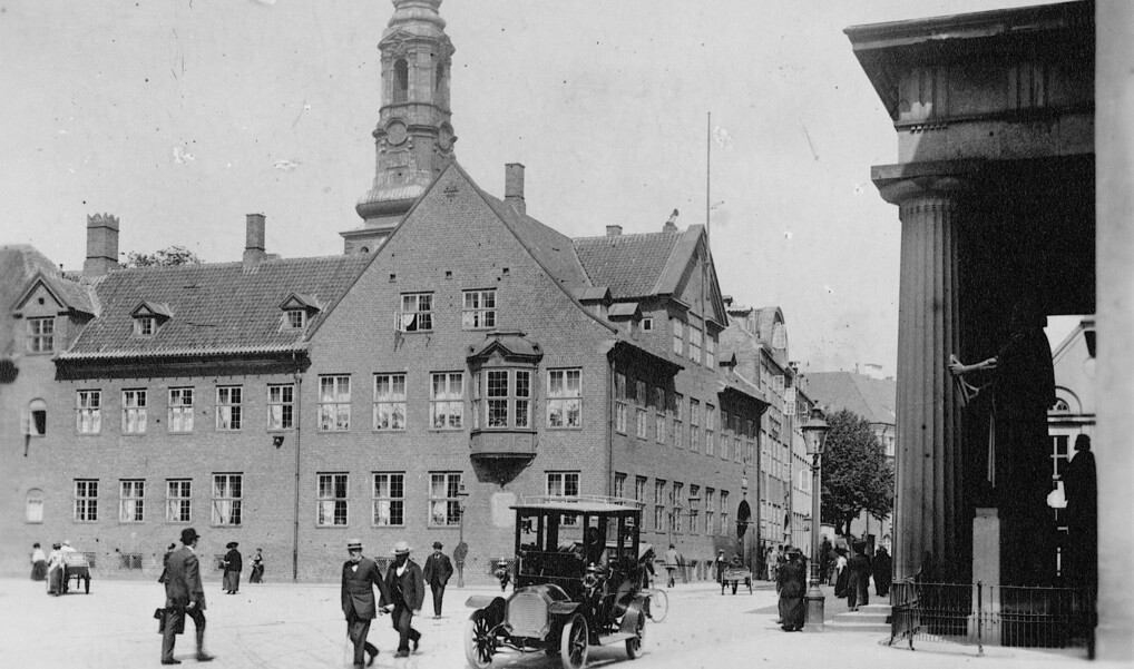 Et sort-hvid billede fra 1910 med automobiler på gaden foran bispegården og domkirken