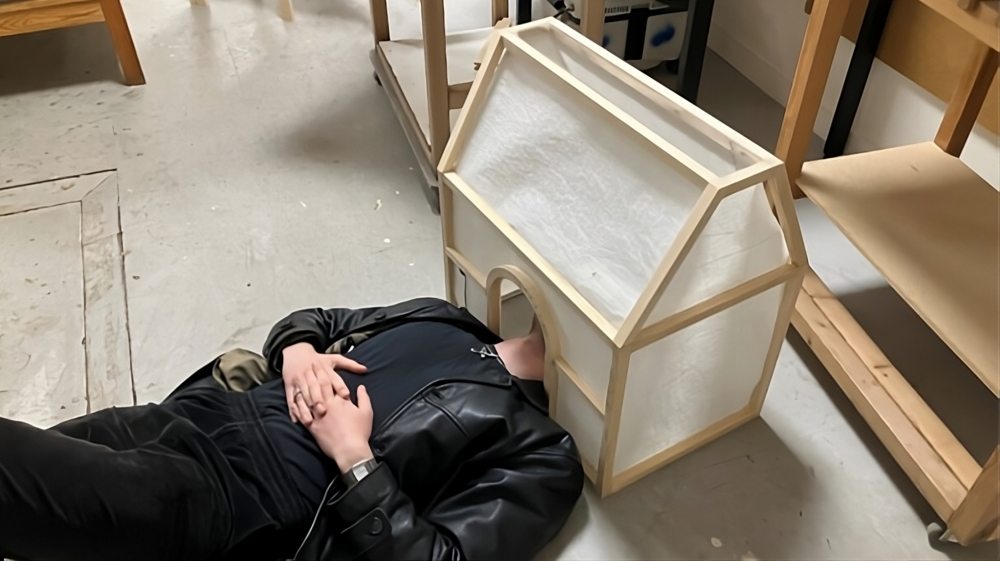 På gulvet ligger sognepræst Rasmus Peytz Stephansen og inspicerer en model af en kirke indefra