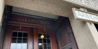 The door to Eliaskirken with white chalk writing above on the door post