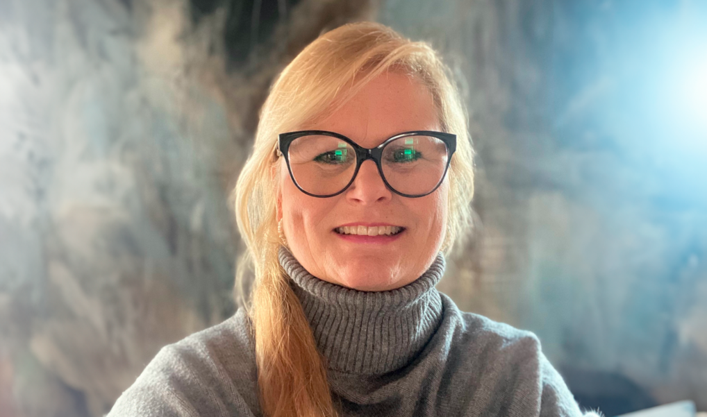 Portræt af Henriette Raudal foran et maleri i Bispegården