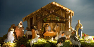 A nativity scene with a bright sun in the background