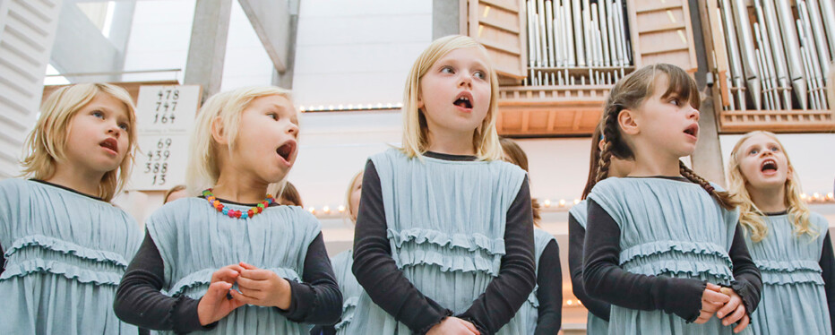 Børn der synger kor foran et orgel