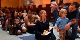 Parents and children sitting down in church at the weekly music and family time